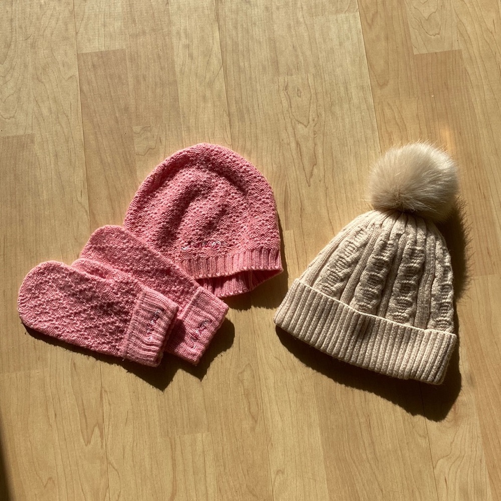 Pair of winter accessories. Beige beanie and pink beanie with matching mittens
